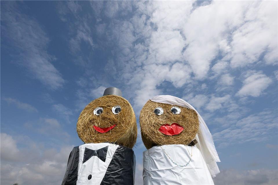 Freundlicher Hingucker: An Ortsrändern aufgestellte Brautpaare aus Stroh weisen häufig auf bevorstehende Hochzeiten hin. (Archivbild)Boris Roessler/dpa
