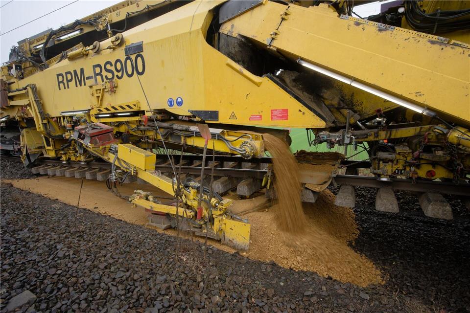 Frische Erde wird als unterste Schicht in das Gleisbett geschüttet und planiert.Henning Kaiser/dpa