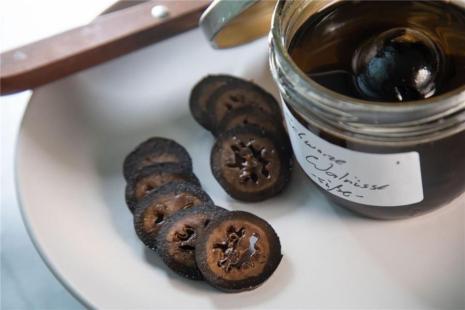 Frühstens an Weihnachten werden die in Gewürzsirup eingelegten schwarzen Walnüsse aufgeschnitten und werden als feines Topping für Eis oder Käse genutzt.Christin Klose/dpa-tmn
