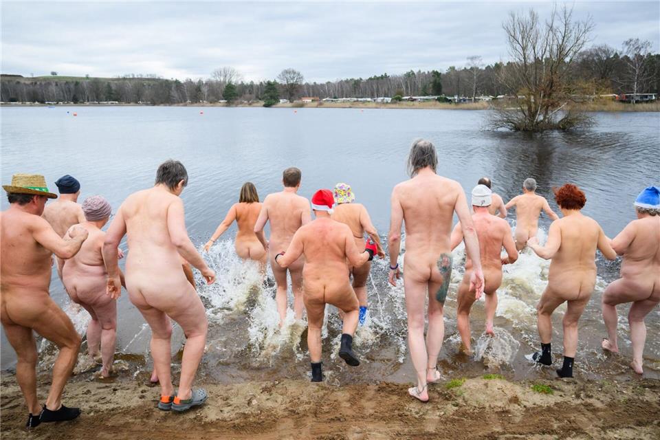 Für das Neujahrs-Nackt-Schwimmen sprangen die Teilnehmer in den kalten Sonnensee.Julian Stratenschulte/dpa