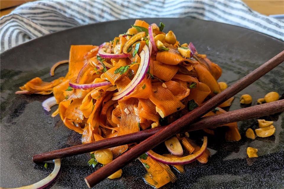 Für den Karottensalat im Asia-Style werden die Möhren nicht geraspelt, sondern mit dem Sparschäler gehobelt, bis nichts mehr von der Möhre übrig ist.   Doreen Hassek/hauptstadtkueche.blogspot.com/dpa-tmn