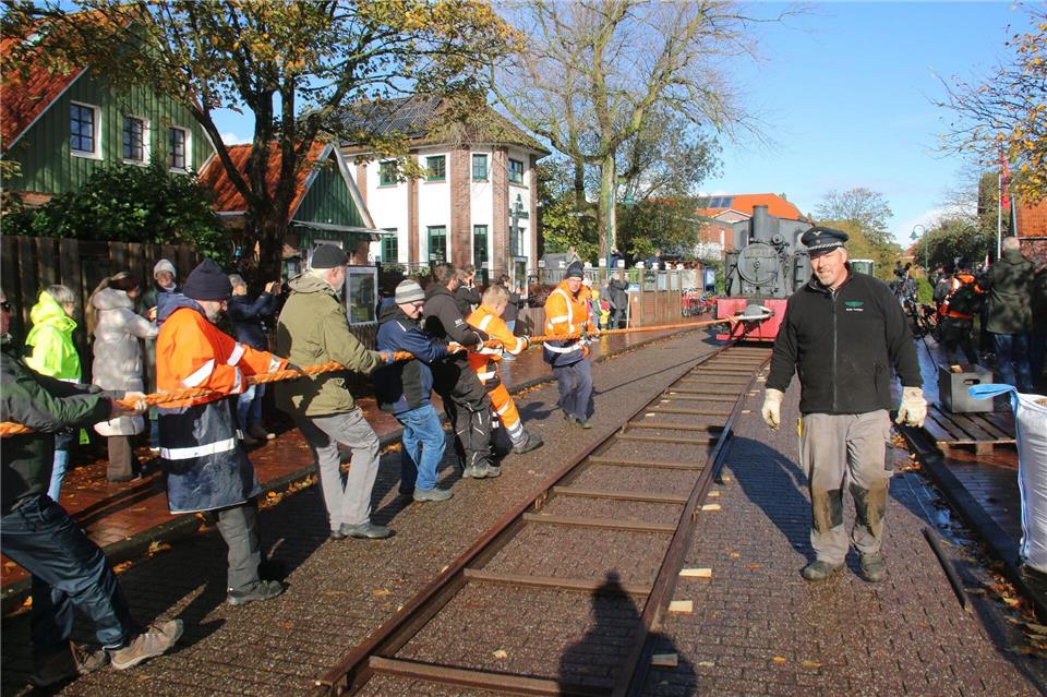 Insel rettet alte Dampflok mit Tau, Teamgeist und Muckis  Für den ungewöhnlichen Transport durchs Inseldorf war Muskelkraft gefragt. Peter Kuchenbuch-Hanken/dpa
