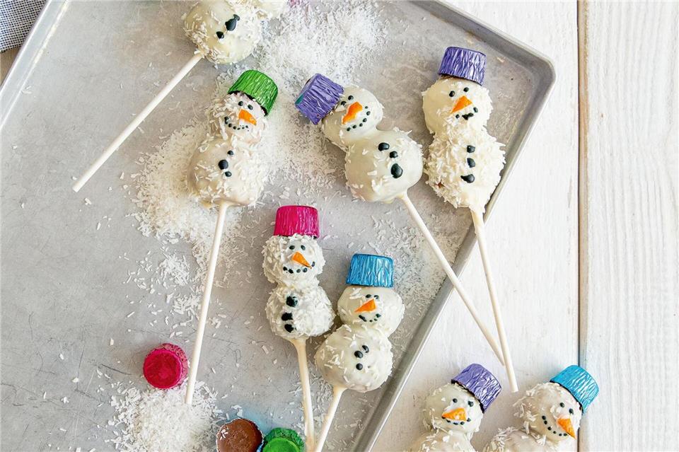 Für die Schneemänner kommt auf jeden Spieß erst eine große Kugel als Schneemannbauch, dann eine kleine Kugel als Kopf. Gesicht und Knöpfe werden mit brauner Zuckerschrift gemalt. Claudia Timmann/StockFood Studios/GU/dpa-tmn