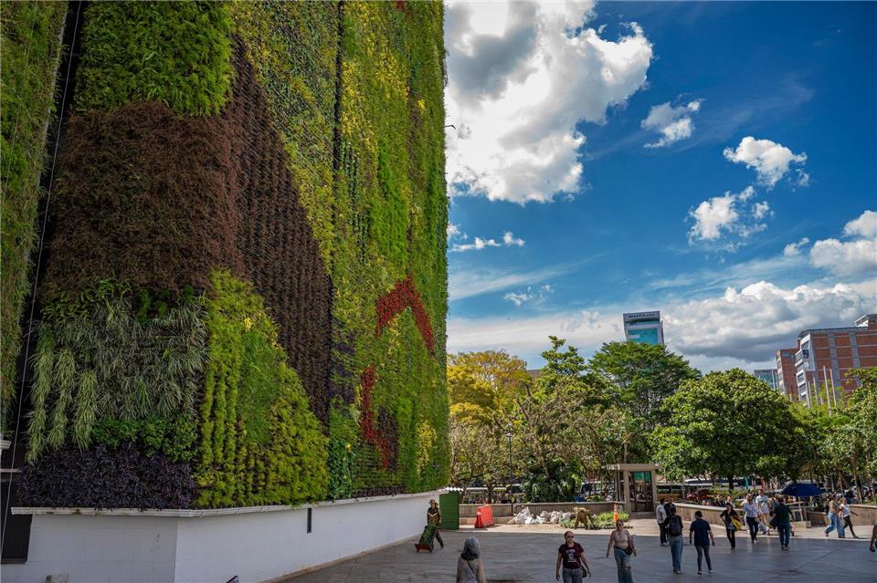 Fußgänger bewegen sich im Schatten einer begrünten Wand in Medellín. (Archivbild)edinson arroyo/dpa