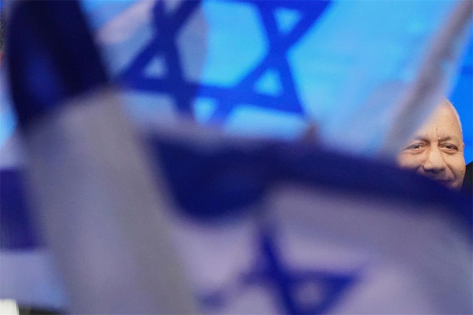 Gadi Eisenkot, Vorsitzender der Jaschar-Partei, ist in Tel Aviv teilweise von israelischen Flaggen verdeckt, als er nach der Veröffentlichung der ersten Ergebnisse der Wählerbefragung zur israelischen Parlamentswahl seine Anhänger begrüßt.Ariel Schalit/AP/dpa