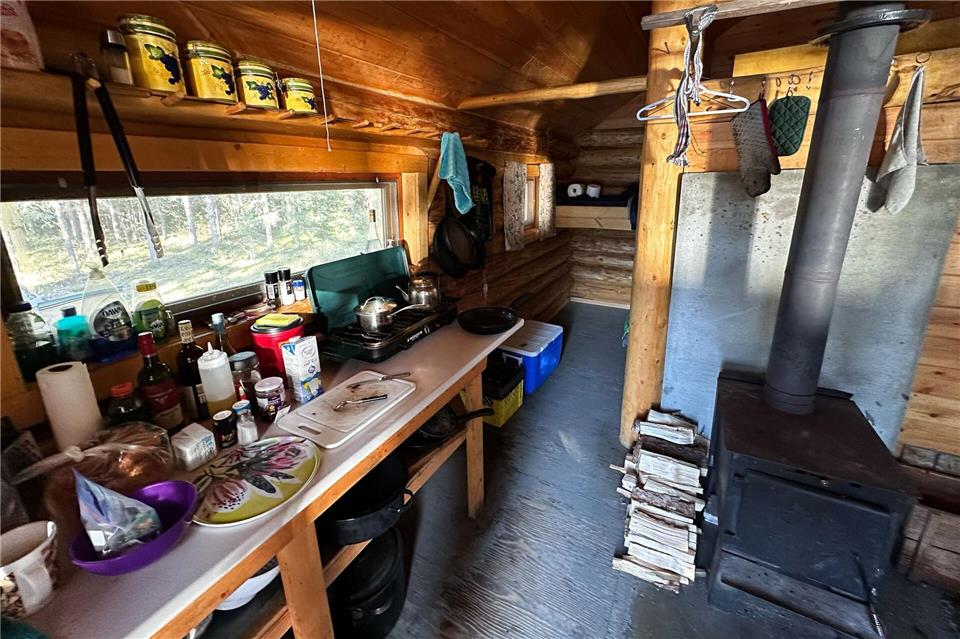 Gaskocher, Plastikgeschirr, Ofen: der Ess-Wohn-Bereich in der Hütte.Ole Helmhausen/dpa-tmn