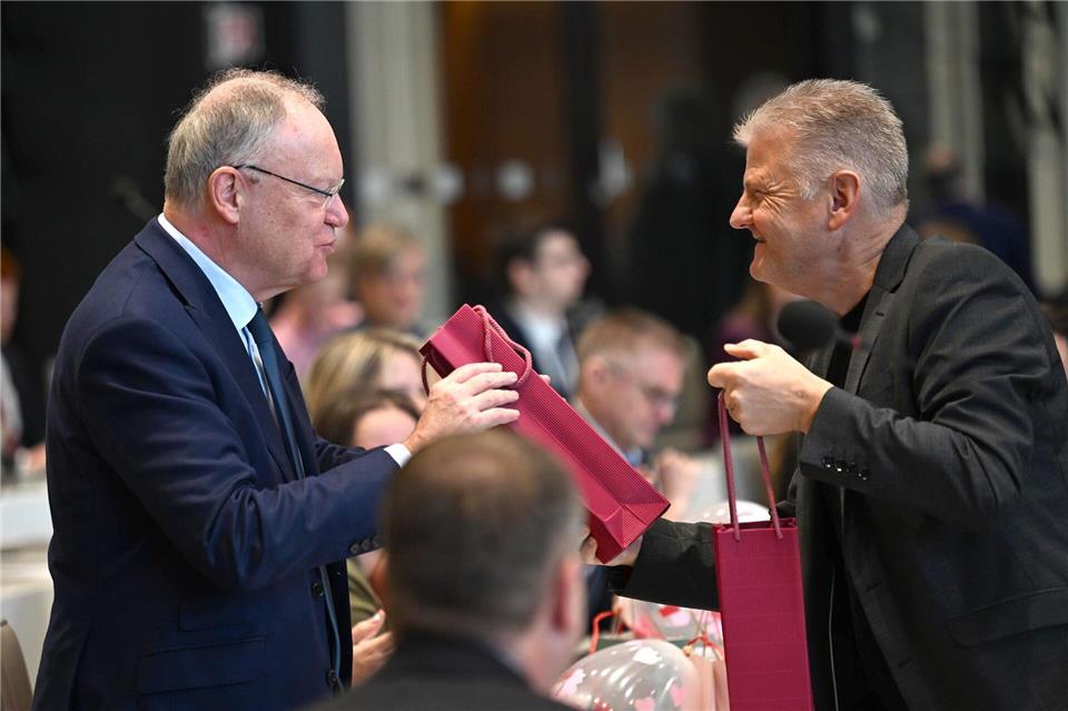 Geburtstagsgruß im Parlament: SPD-Fraktionschef Politze (r) überreicht Ex-Ministerpräsident Weil (l) eine Flasche Wein.Shireen Broszies/dpa