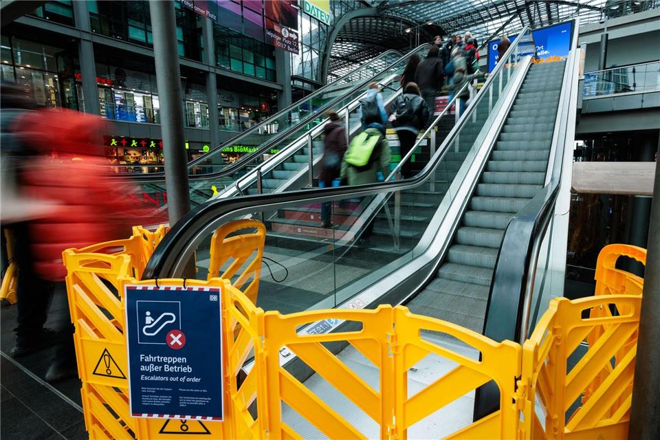 Gelbe Absperrungen versperren den Zugang zu den defekten Rolltreppen am Berliner Hauptbahnhof, während Reisende die Treppe nutzen müssen.Carsten Koall/dpa