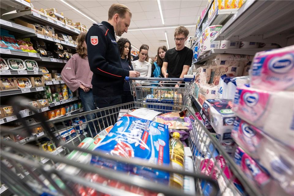 Gemeinsam mit Lehrer Florian Hambach kaufen die Schülerinnen und Schülern einen Notvorrat für eine vierköpfige Familie ein.Marijan Murat/dpa