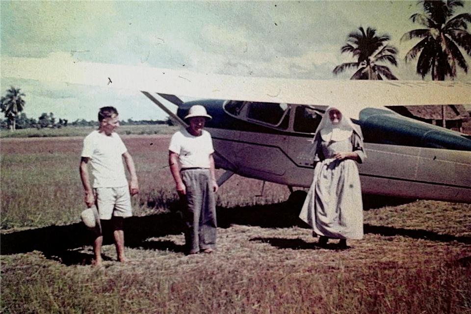Georg Plank (links) mit einem Pater und einer Missionsschwester vor einer Cessna.