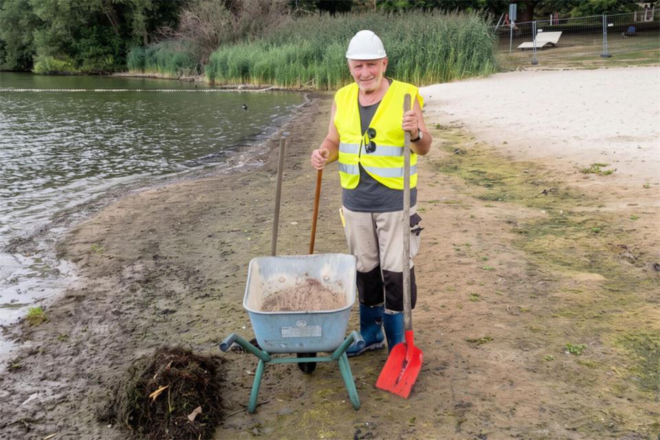 Gerd Fiebelkorn (85) packt an: Mit Schaufel und Schubkarre steht er am Strand der Badebucht und holt Pflanzenreste vom Ufer.