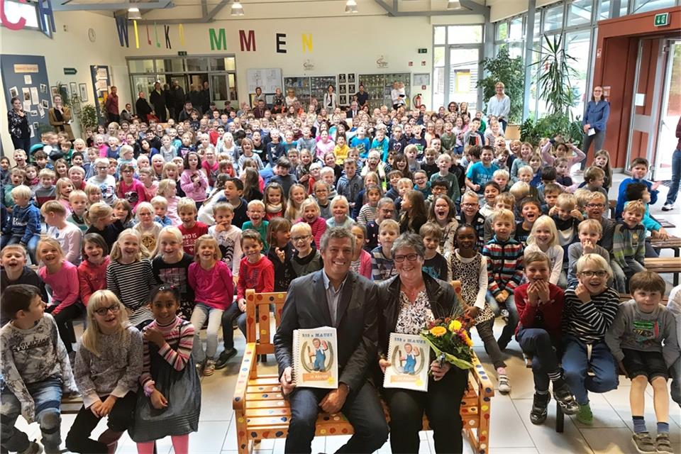 Gerd und Ida Benning inmitten der Schüler der Grundschule. Zum Abschied erhielt der Hausmeister zwei gemalte Bücher mit dem Titel „Hausi in Aktion“. 