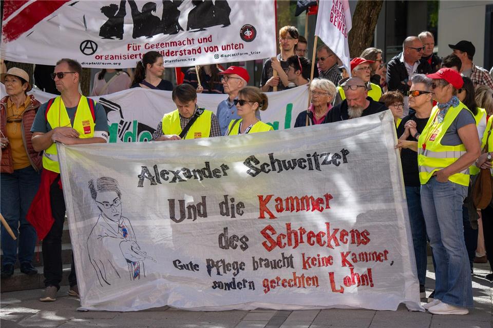 Gerechten Lohn in der Pflege fordern diese Demonstranten bei der zentralen DGB-Kundgebung in Trier und richten sich an den rheinland-pfälzischen Noch-Ministerpräsidenten Alexander Schweitzer (SPD).Harald Tittel/dpa