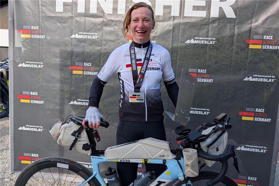 Geschafft: Lisa Brömmel nach dem „Race Across Germany“ im Trikot der Deutschen Meisterin mit Pokal und Medaille.