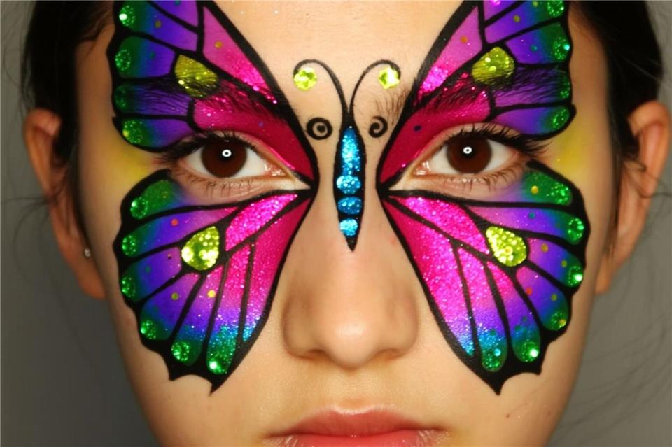 Geschwungene Flügelformen und kräftige Farben verwandeln das Gesicht in ein farbenfrohes Schmetterlingsmotiv.Lukas Wythe/dpa-tmn