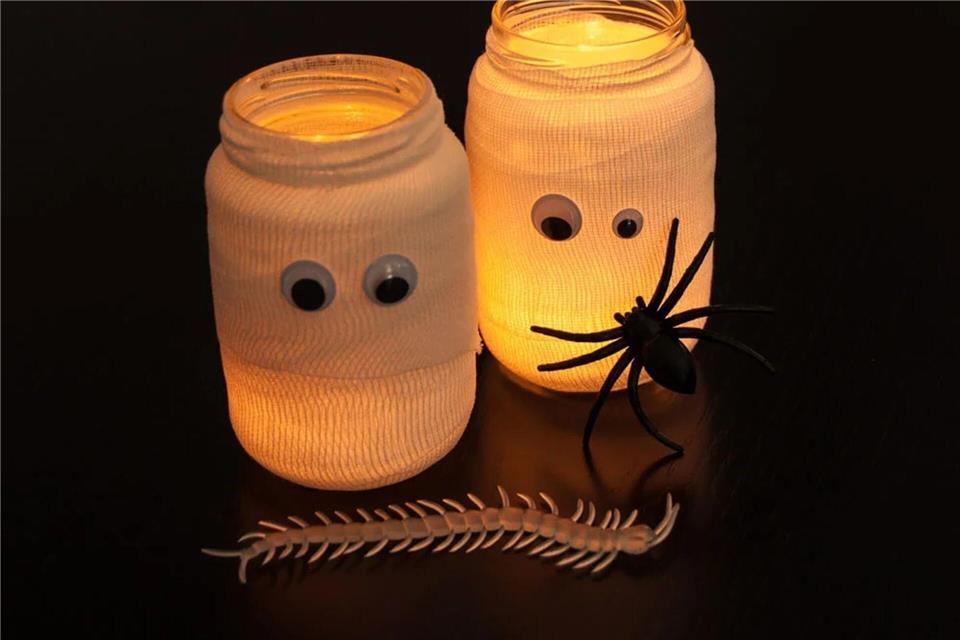 Gläser im Mumien-Look sorgen für die passende Beleuchtung an Halloween.DIY-Academy/dpa-tmn