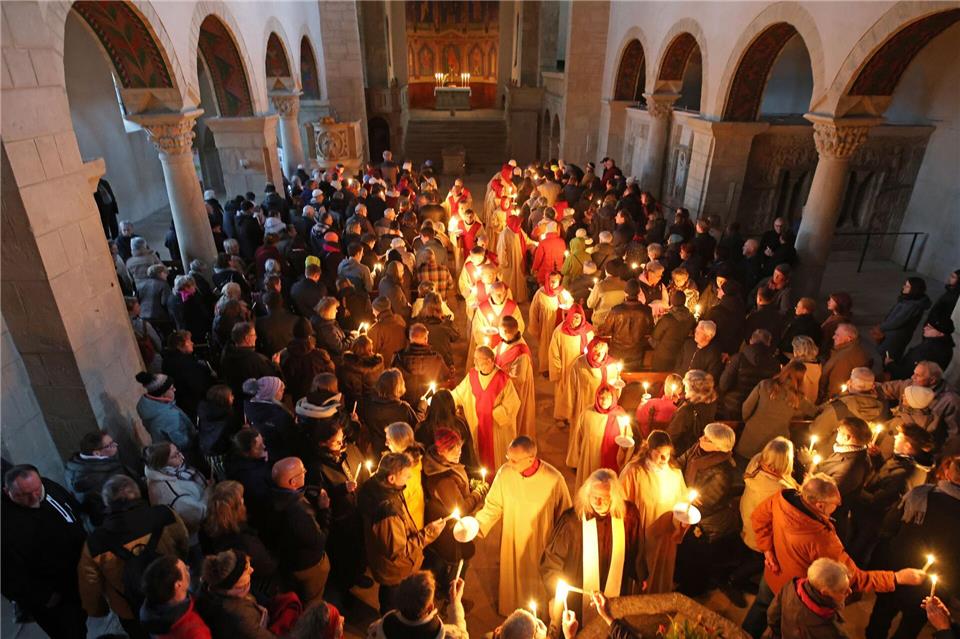 Gläubige verteilen das Osterlicht in der Stiftskirche St. Cyriakus. Matthias Bein/dpa
