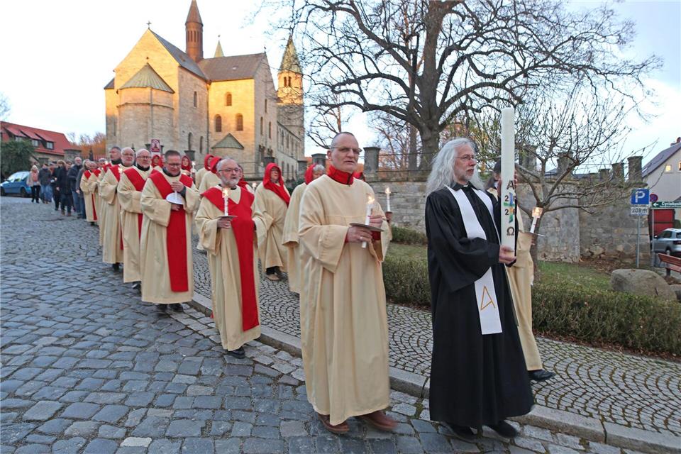 Gläubige ziehen mit dem Osterlicht aus der Stiftskirche St. Cyriakus durch den Harzort Gernrode.Matthias Bein/dpa