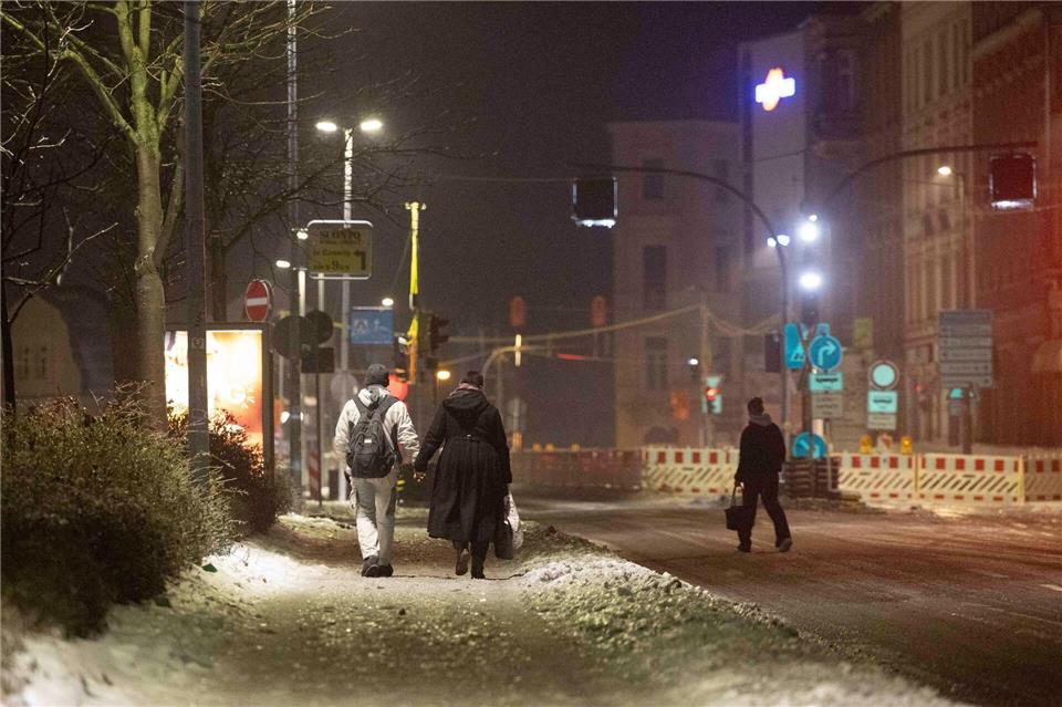 Glatte Straßen behindern den Autoverkehr und Fußgänger müssen Achtgeben.Daniel Wagner/dpa