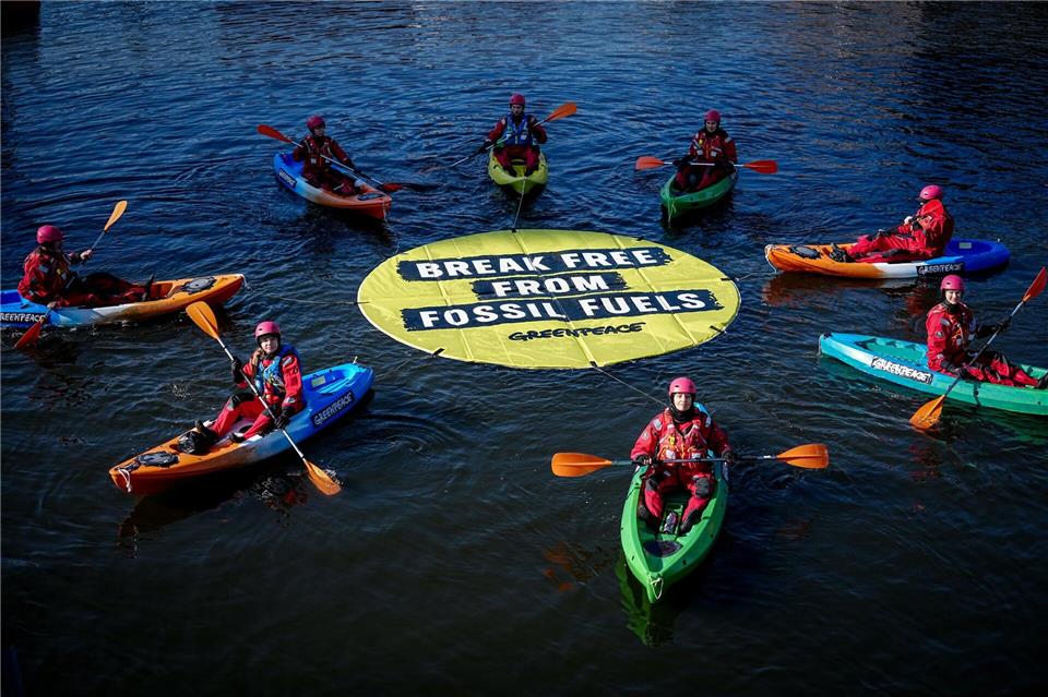 Greenpeace fordert bei einer Aktion am Veranstaltungsort die Abkehr von fossilen Energien.Kay Nietfeld/dpa