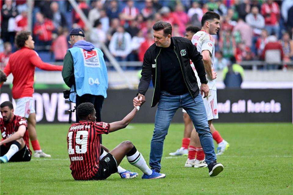Große Enttäuschung: Hannovers Trainer Christian Titz hilft seinem Spieler William Kokolo nach dem verpassten Aufstieg wieder auf die Beine.Swen Pförtner/dpa