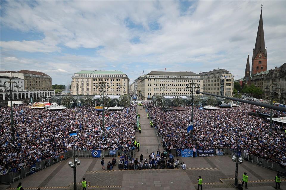 HSV-Fans stehen auf dem Rathausmarkt vor dem Hamburger Rathaus und feiern ihren Club.Christian Charisius/dpa
