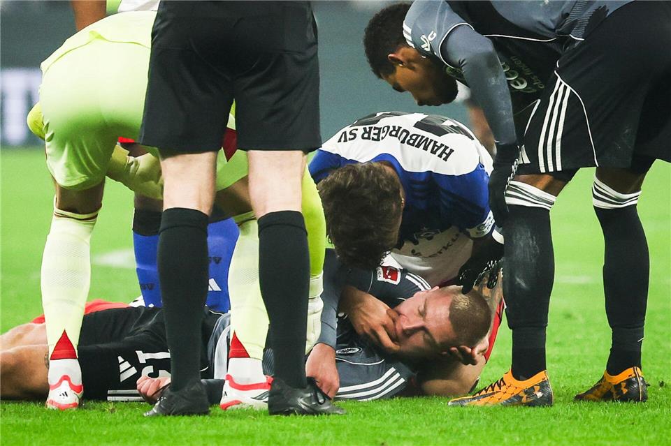 HSV-Verteidiger Luka Vuskovic hilft dem am Boden liegenden Eintracht-Profi Rasmus Kristensen. Christian Charisius/dpa