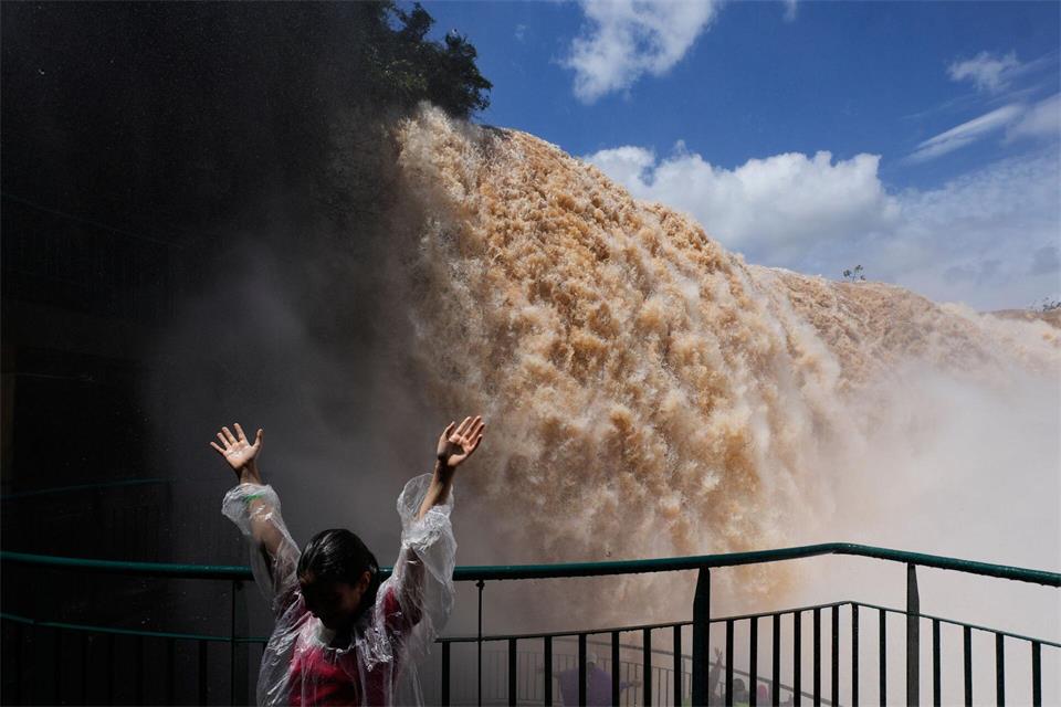 Hände hoch vor den Wassermassen der Iguazú-Wasserfälle in BrasilienJorge Saenz/AP/dpa