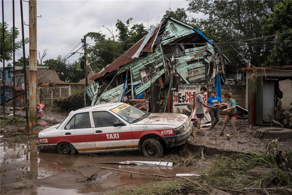Häuser wurden beschädigt, Autos mit der Strömung wegschwemmt.Felix Marquez/AP/dpa