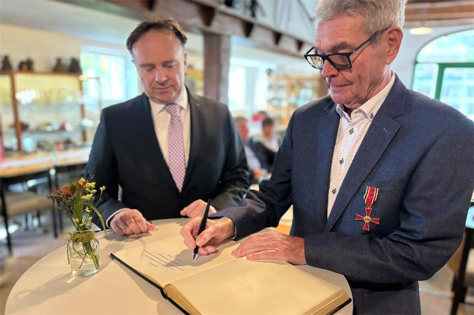 Hans-Peter Kemper trägt sich in Heidens Goldene Buch am Tag der Verleihung des Bundesverdienstkreuzes ein.