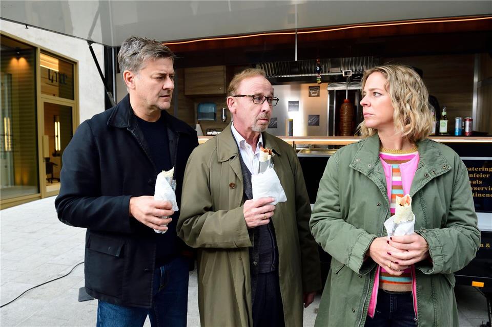 Harald Neuhauser (l, Marcus Mittermeier), Ludwig Schaller (Alexander Held) und Angelika Flierl (Bernadette Heerwagen) stehen vor einem Imbissstand.Jürgen Olczyk,/ZDF/dpa