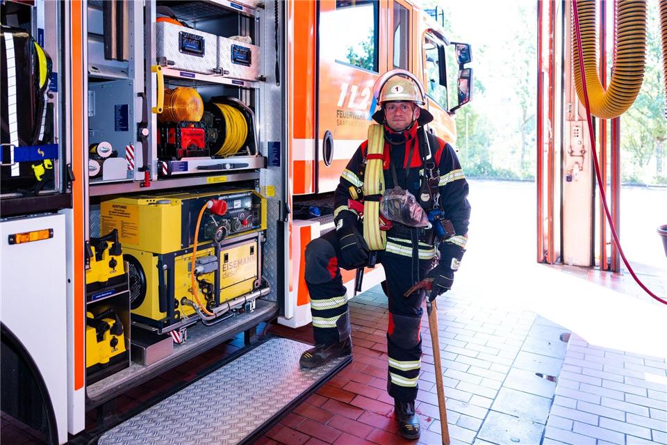 Hauptbrandmeister Kevin Michel steht in voller Schutzausrüstung neben einem Löschfahrzeug der Berufsfeuerwehr Saarbrücken.Laszlo Pinter/dpa