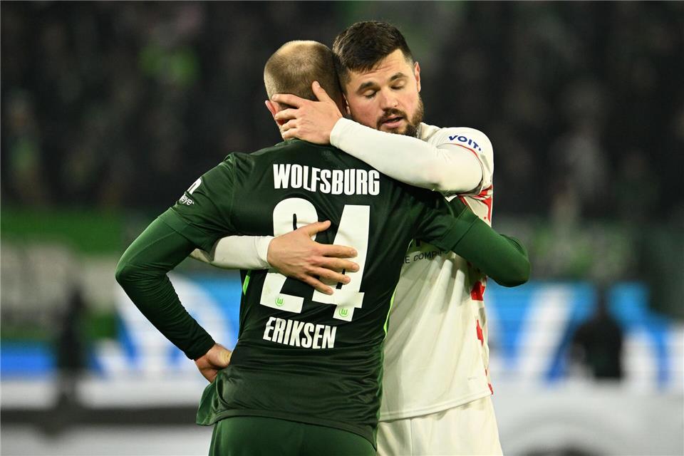 Heidenheims Marnon Busch umarmt Wolfsburg-Star Christian Eriksen.Swen Pförtner/dpa