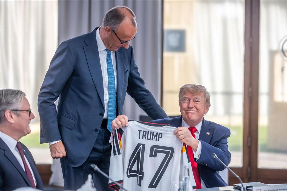 Helfen kleine Aufmerksamkeiten? Zum Geburtstag bekam Trump von Kanzler Merz ein Fußball-Trikot geschenkt. (Archivbild)Michael Kappeler/dpa-Pool/dpa