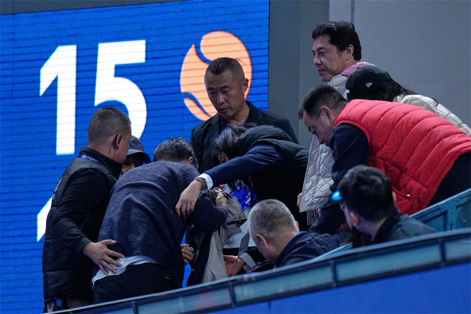 Helfer kümmern sich um einen Mann, der von einem Ball verletzt wurde, den der Russe Medwedew in die Zuschauerränge geschlagen hatte.Andy Wong/AP/dpa