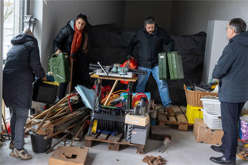 Helfer tragen Benzinkanister in den Lastwagen. Helmut Fricke/dpa