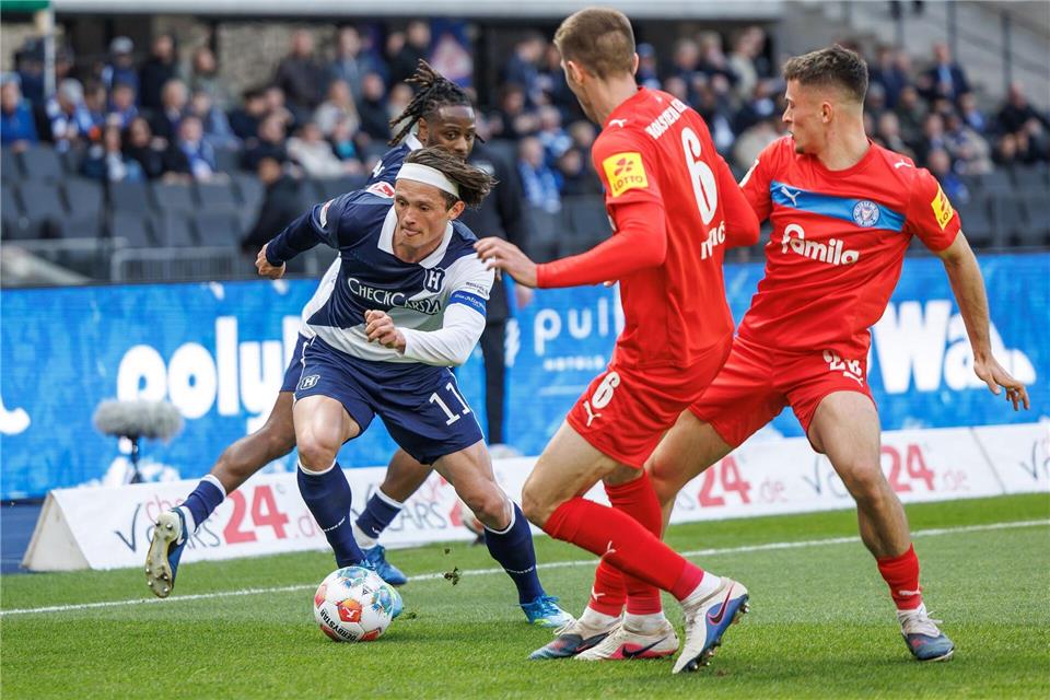 Herthas Fabian Reese (l.) zieht an zwei Kieler Gegenspielern vorbei. Andreas Gora/dpa