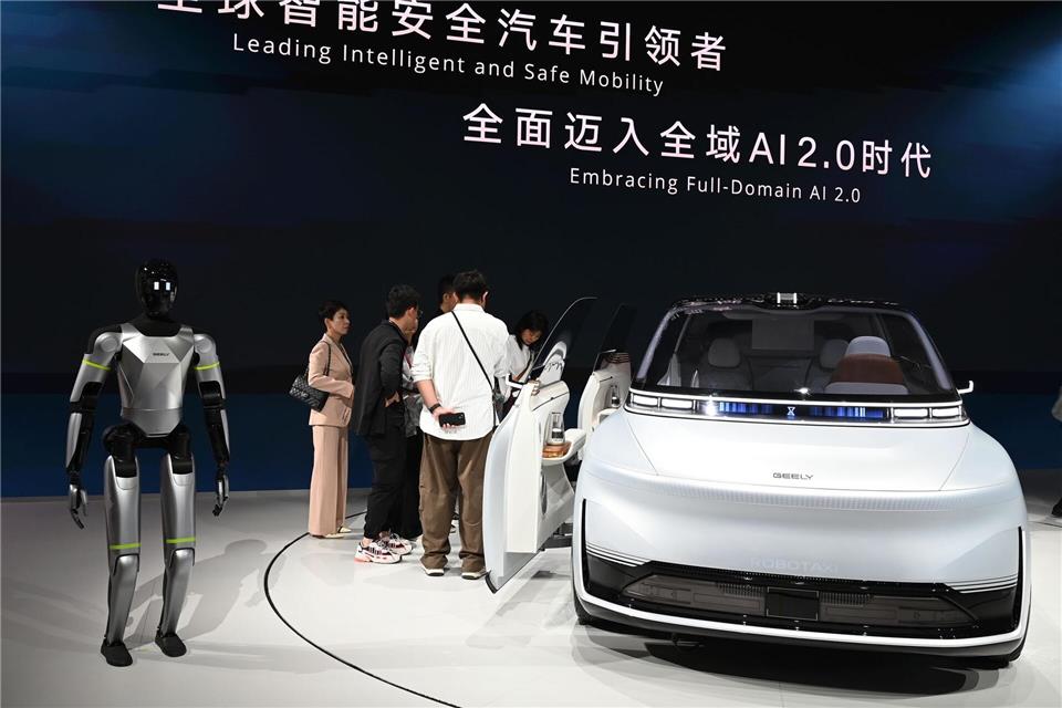 Hier präsentiert Geely ein Auto samt humanoidem Roboter auf einer Automesse in Peking. Nun wagt die Firma den Sprung nach Spanien, um dort Autos zu bauen. Johannes Neudecker/dpa