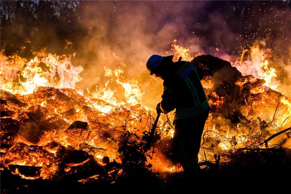 Hier schichten Feuerwehrkräfte ein traditionelles Osterfeuer im Landkreis Hildesheim auf. (Archivbild)Julian Stratenschulte/dpa