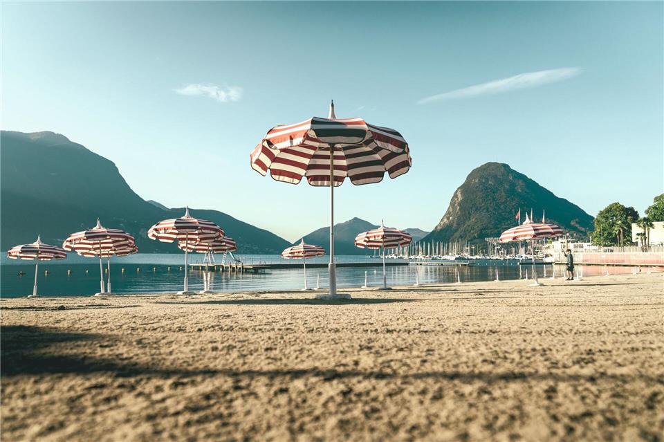 Hier spricht man Italienisch: mediterranes Flair mir Alpenblick am Sandstrand des Lido di Lugano.Lorenz Richard/Schweiz Tourismus/dpa-tmn