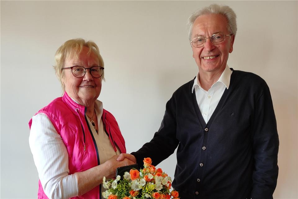 Hildegard Gülker wird mit Blumenstrauß und Dankeschön-Tafel des Heimatvereins von Carlo Behler verabschiedet.