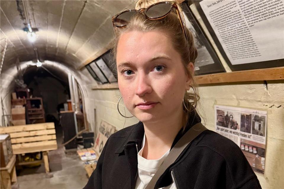 Historikerin Stephanie Kanne zeigt im Röhrenbunker eine geschmolzene Glasflasche.Wolfgang Stelljes/dpa-tmn