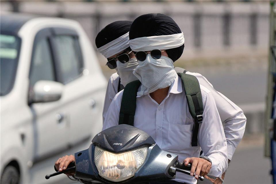 Hitze in Indien: Pendler schützen sich in Jammu vor der SommeChanni Anand/AP/dpa