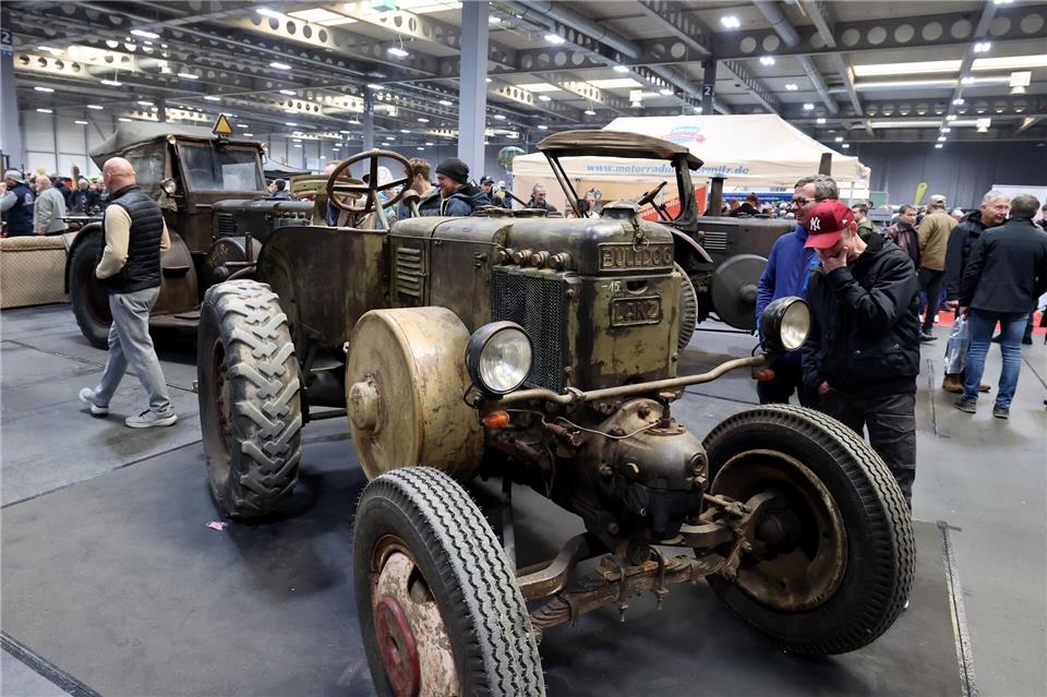 Hochglanzautos stehen auf der Messe neben alten Traktoren. Bodo Schackow/dpa