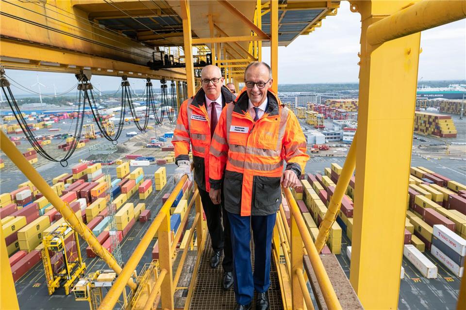 Hoffentlich schwindelfrei: Bundeskanzler Friedrich Merz und Bremens Bürgermeister Andreas Bovenschulte (SPD) stehen auf einer Containerbrücke im Überseehafen in Bremerhaven.Sina Schuldt/dpa Pool/dpa
