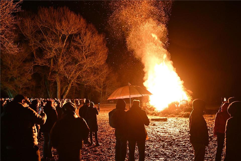 Hunderte Besucher schauen sich das Funkenfeuer an, das am Abend am Ufer des Bodensees am Malereck angezündet wurde.Felix Kästle/dpa