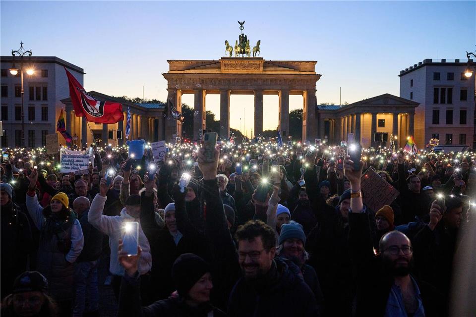 Hunderte Demonstranten bilden mit Smartphones und Feuerzeugen ein Lichtermeer. Annette Riedl/dpa