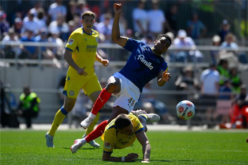 Ikem Ugoh von Holstein Kiel (M) wird von Braunschweigs Andi Hoti gestoppt. Gregor Fischer/dpa