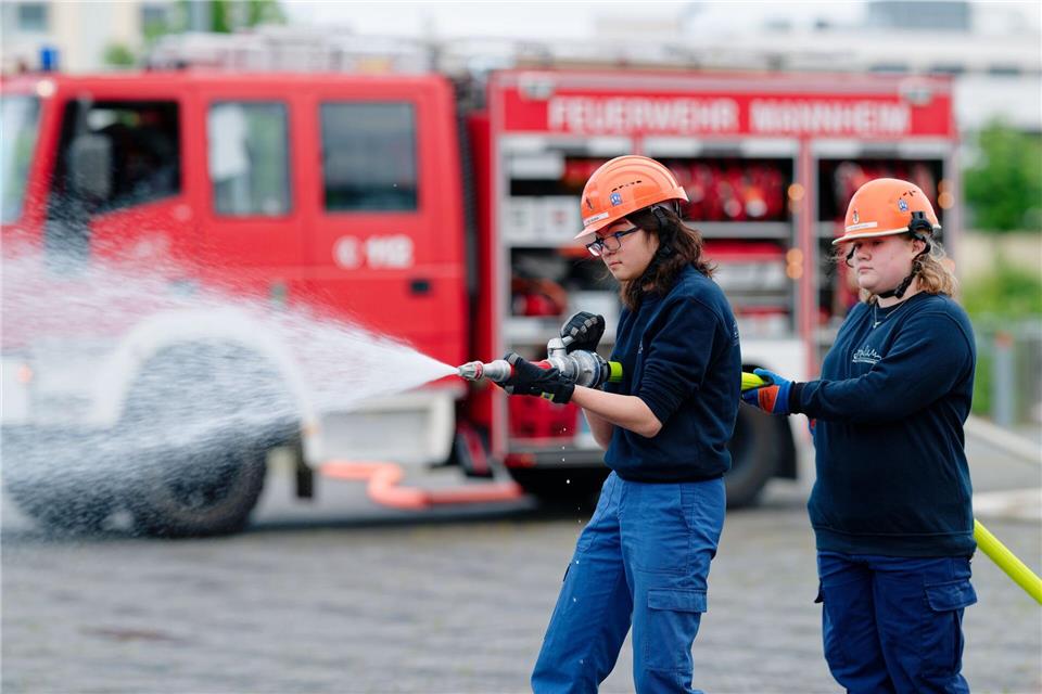 Ilias (links) und Annabella, Mitglieder der Jugendfeuerwehr in Mannheim, halten bei einer Übung einen Feuerwehrschlauch in den Händen.Uwe Anspach/dpa