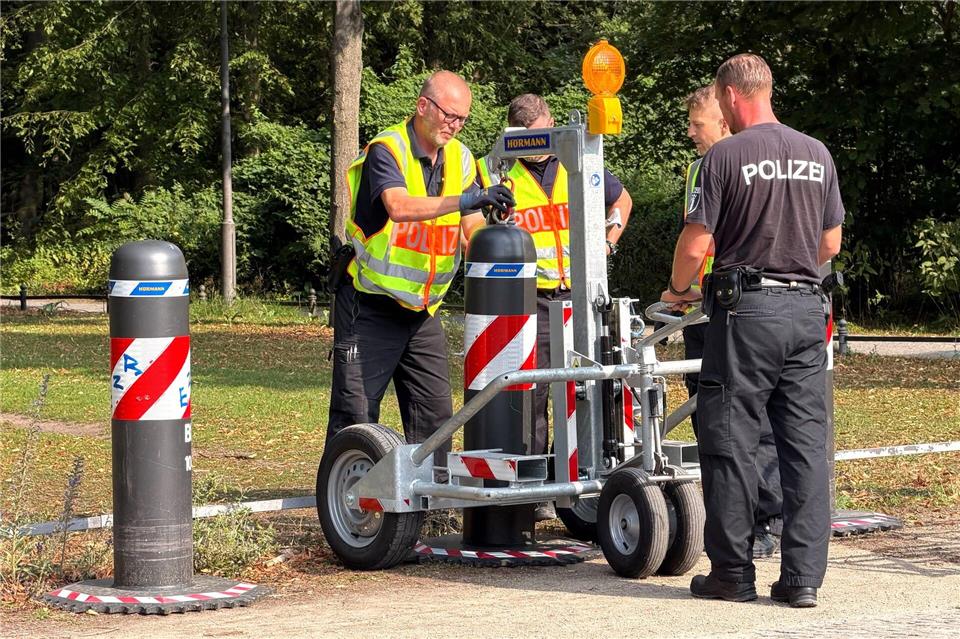 Im Berliner Tiergarten stellen Polizisten Poller auf, um die Durchfahrt von Autos zu verhindern.  Sven Kaeuler/dpa